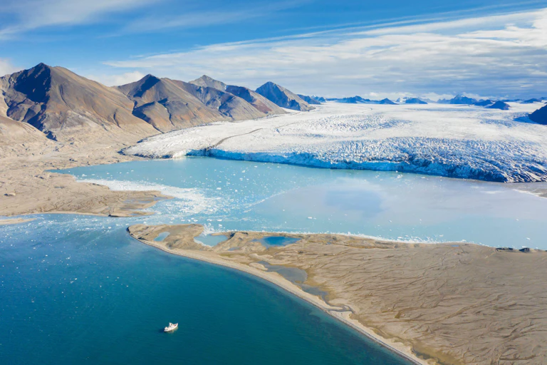 Aerial view of the point where an icy glacier becomes a river.