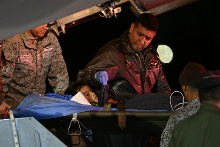L'un des quatre enfants indigènes retrouvés vivants après 40 jours d'errance dans la forêt amazonienne colombienne à la suite d'un accident d'avion, est brancardé hors de l'avion lors de l'atterrissage à la base militaire de CATAM à Bogota, le 10 juin 2023. Quatre enfants indigènes disparus depuis plus d'un mois dans la forêt amazonienne colombienne à la suite d'un accident d'avion ont été retrouvés vivants, a déclaré le président Gustavo Petro le 9 juin 2023