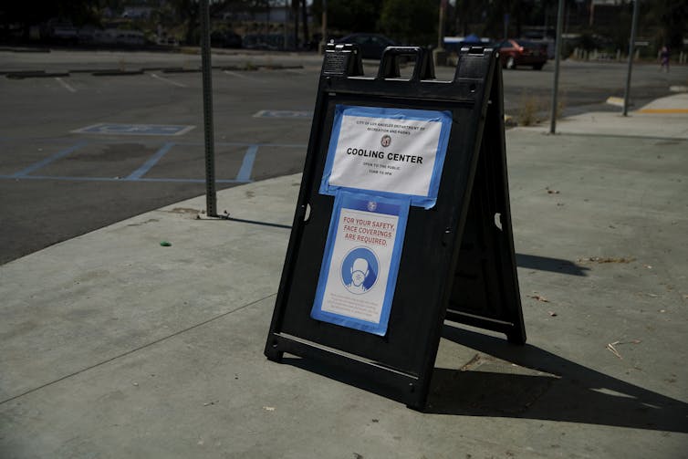 Um sinal exibido em uma calçada pública declara um 'centro de resfriamento' nas proximidades.