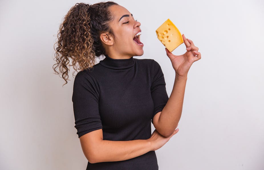 Woman in black top holding cheese.