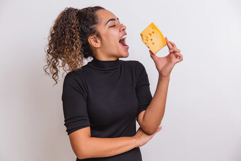 Woman in black top holding cheese.