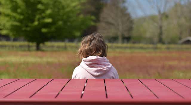Anxious child sits on a bench
