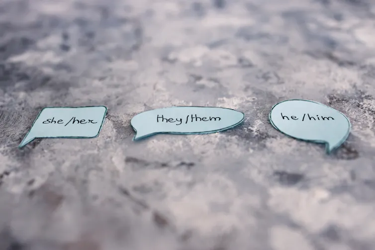 Pieces of paper showing different pronouns.