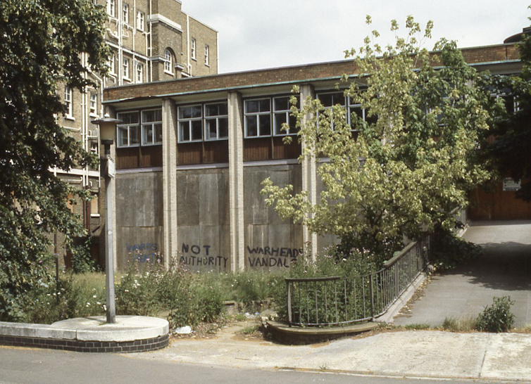 Overgrown and disused hospital building with graffiti