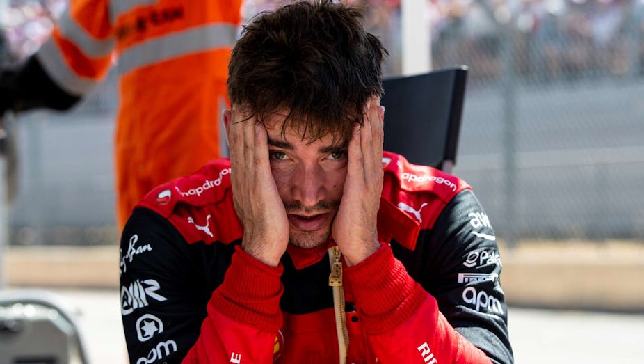 Un pilote de Formule 1 se tient la tête entre les mains,visiblement nerveux.