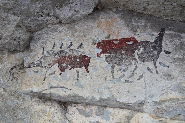 Rock art painting showing buck and fish.