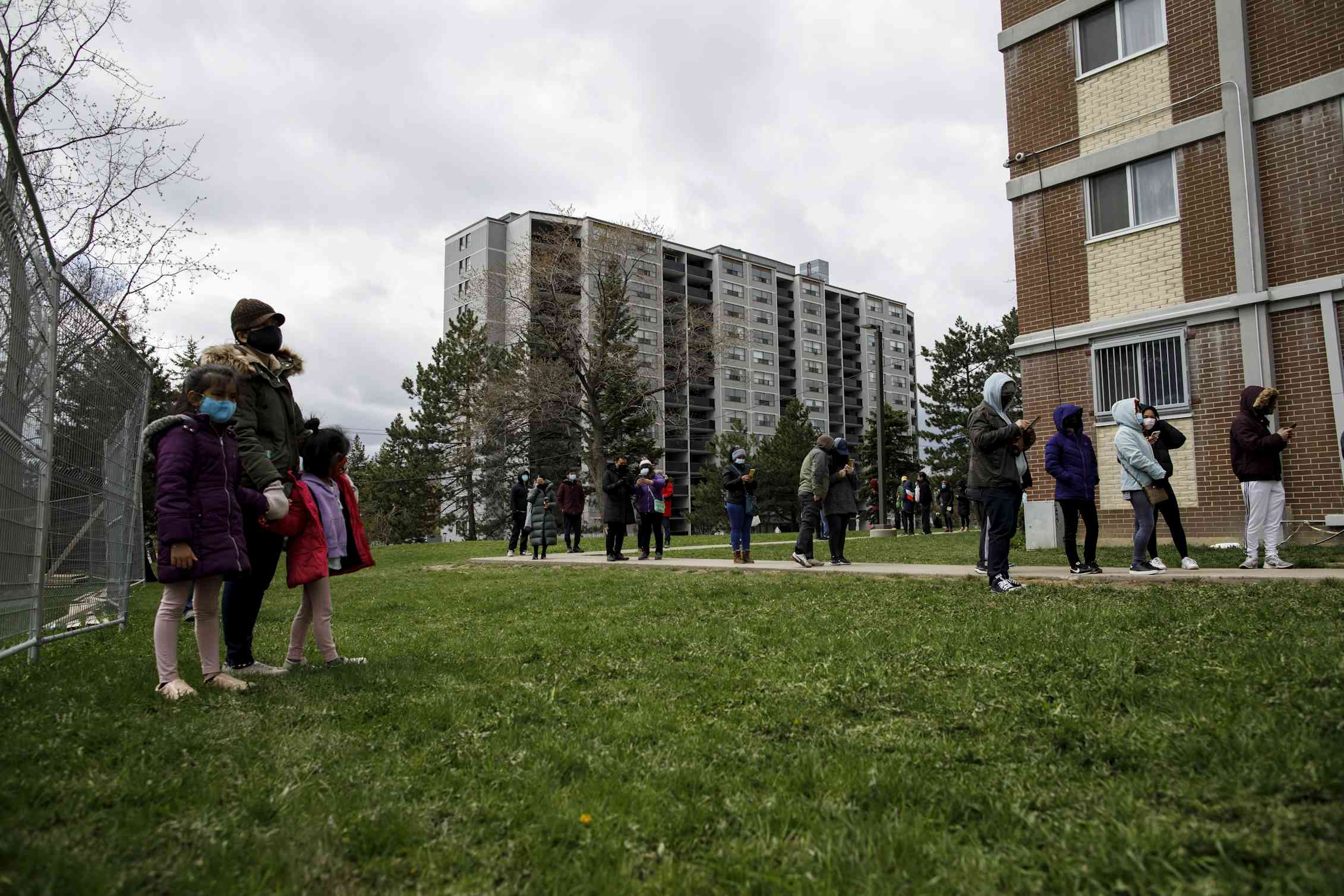 People seen lining up outside an apartment building.