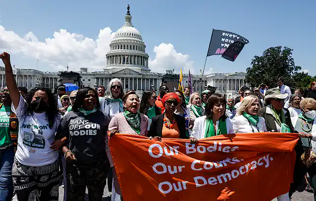 A group of Black and white women protest Supreme Court decision that allows states to ban abortions.