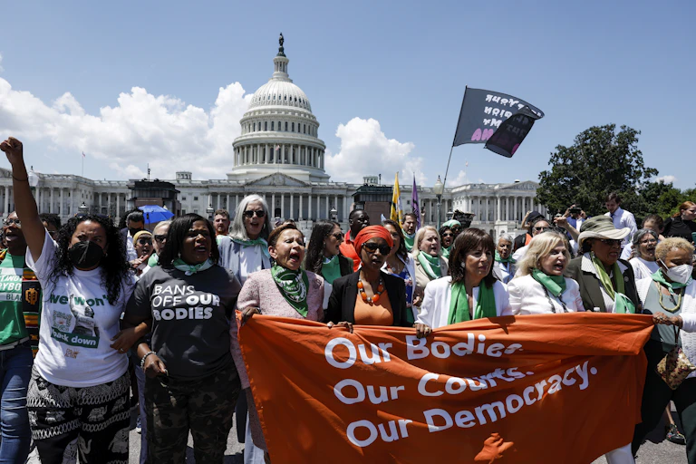 A group of Black and white women protest Supreme Court decision that allows states to ban abortions.