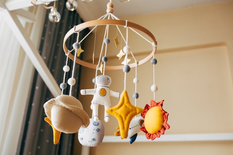 Crib mobile in the form of space icons and an astronaut