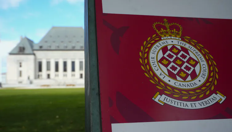 Se puede ver la Corte Suprema detrás de una pancarta roja y blanca que dice Corte Suprema de Canadá.