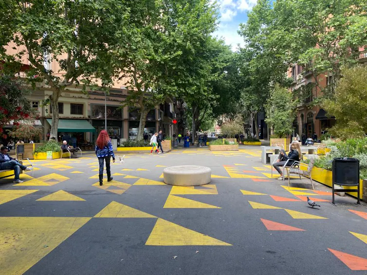 A low-traffic neighbourhood with curbside seating and colourful decoration.