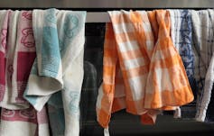 Tea towels hanging to dry on the oven door.