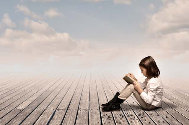 Una niña lee en un entorno celestial.