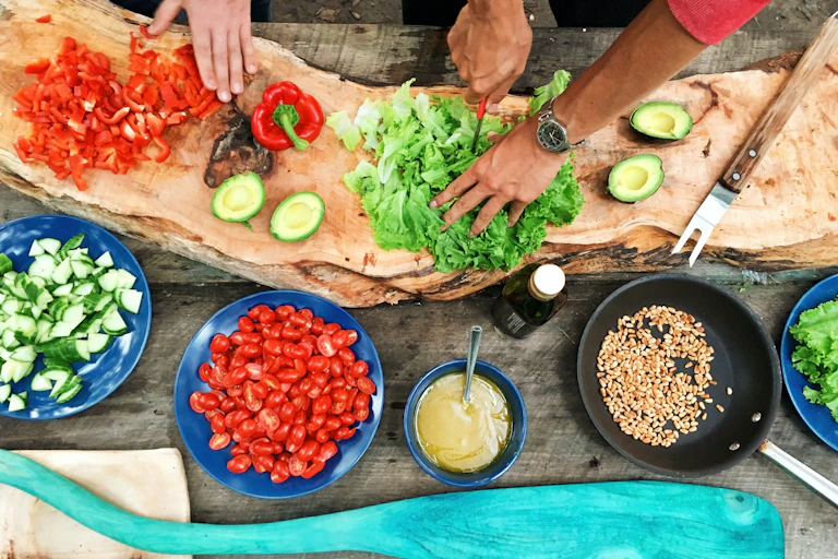 personnes qui cuisinent des légumes vues de haut