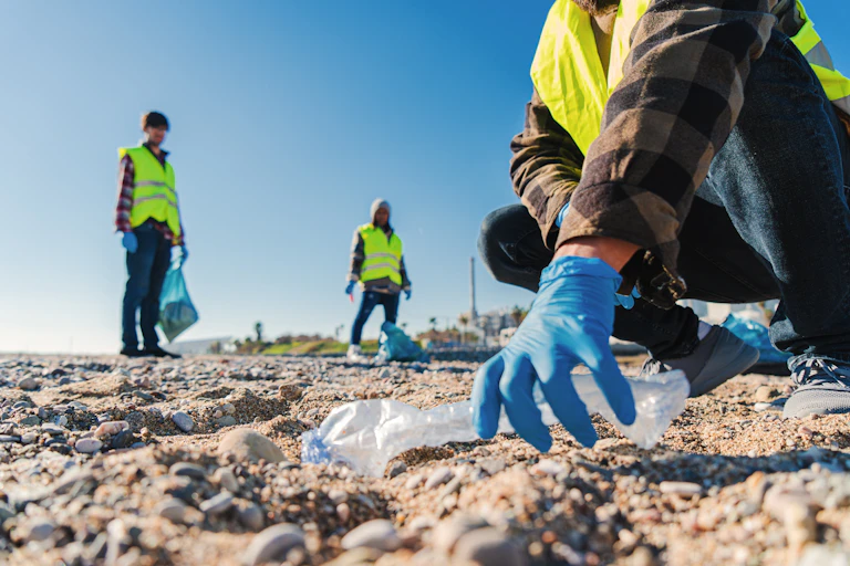 people picking up plastic litter on beach