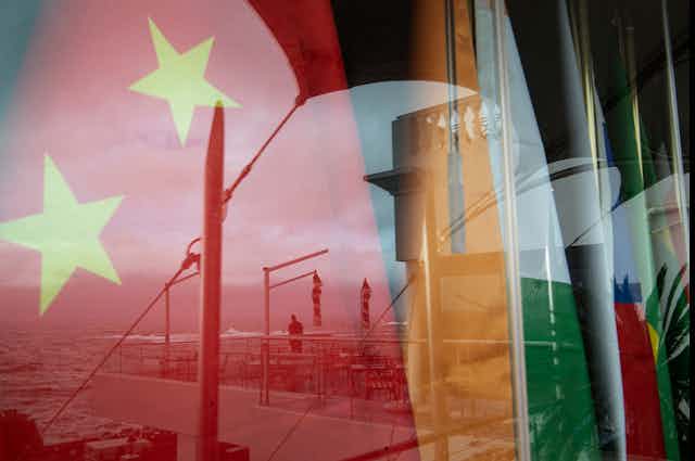 A window behind which are the flags of several nations.