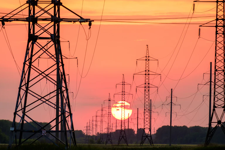 Electricity pylons with setting Sun in background