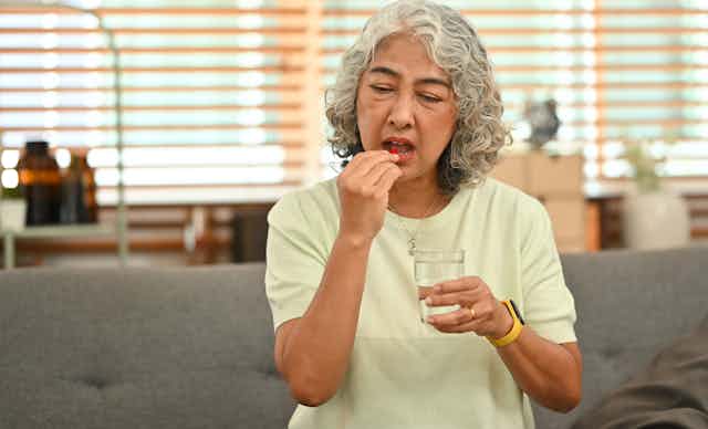 Older woman takes a multivitamin