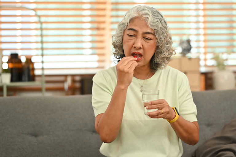 Older woman takes a multivitamin