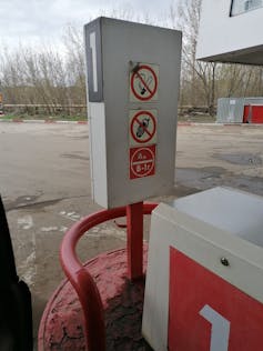 A sign at a petrol station showing smoking and mobile phones are prohibited