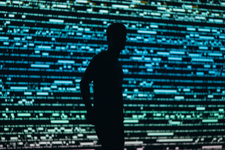 ombre humaine devant lignes de codes