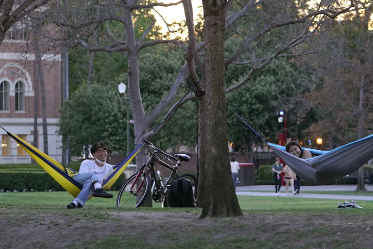 People seen in hammocks on a campus.
