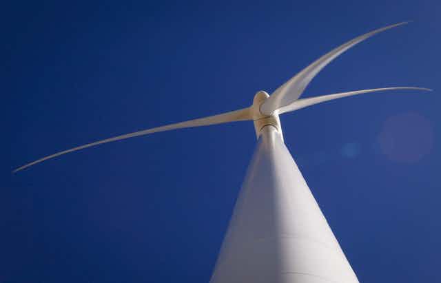 A wind turbine is seen from below.