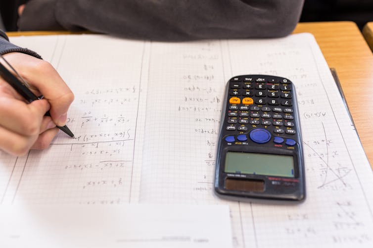 A student working on math equations with their calculator.
