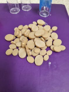 A pile of yellow coloured oval wafers on a purple background