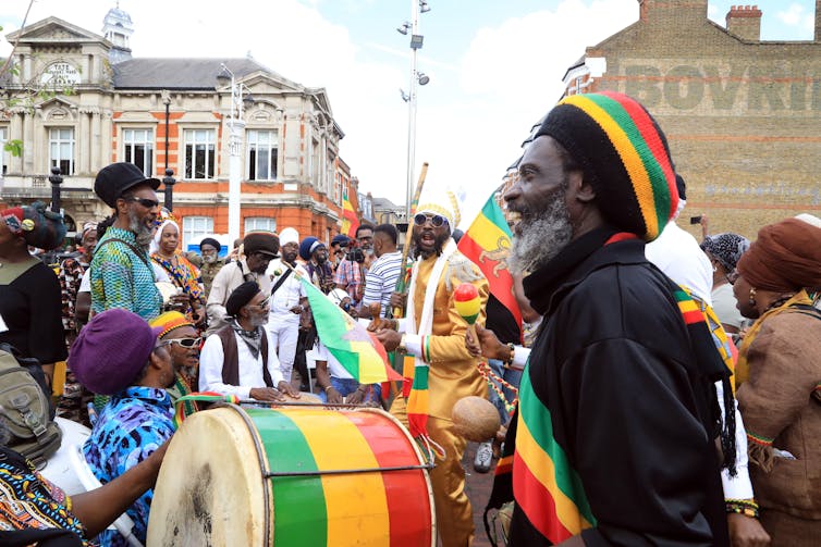People with drums gather in a public square.