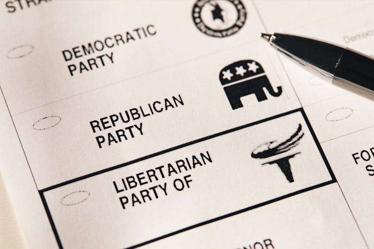 A black and white ballot shows choices for Republican, Democrat and Libertarian.