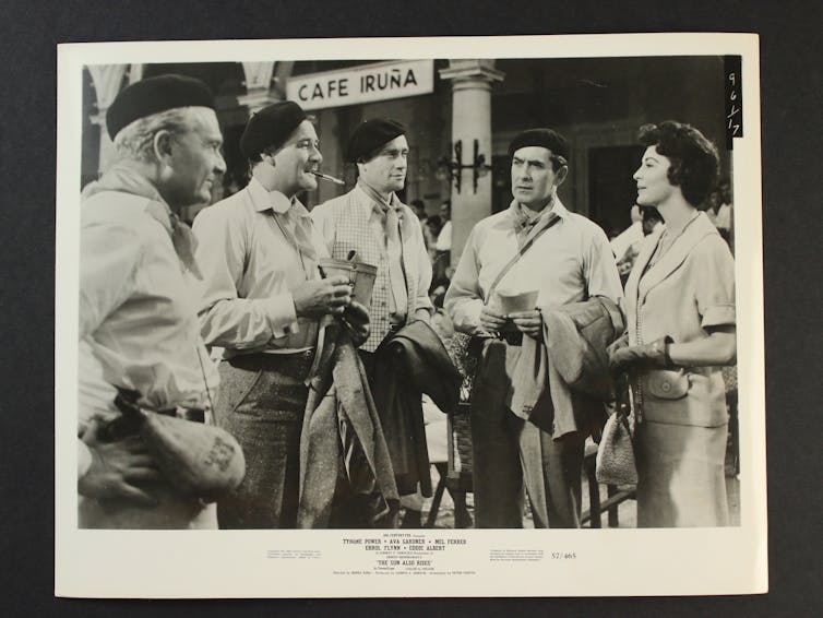 In front of Café Iruña, four men and a woman talk