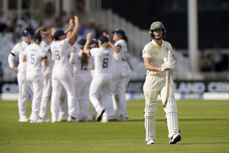 In the background, a team celebrates. Perry walks away.