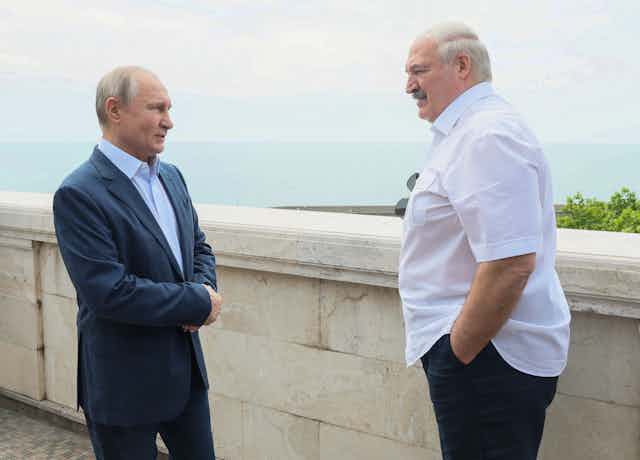 Vladimir Putin and Alexander Lukashenko talk on a terrace overlooking the sea