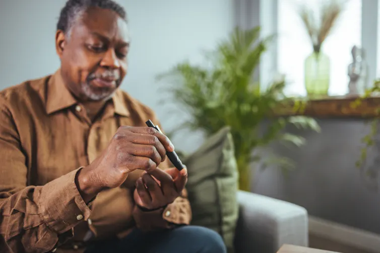 Man pricking his finger for blood glucose check.