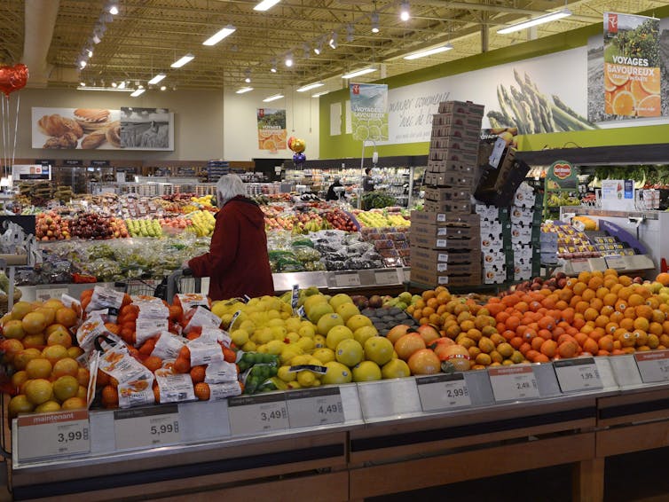 A woman shops in the fresh produce section of a supermarket.