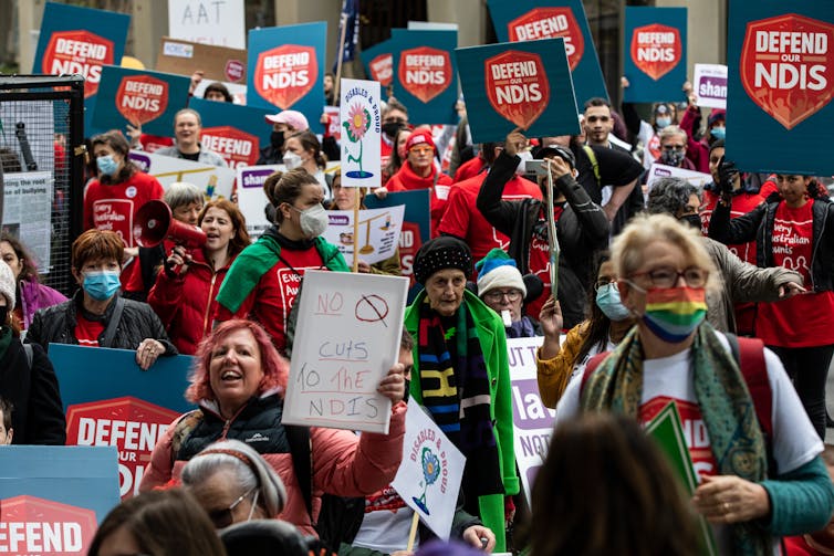 المتظاهرين مع لافتات تقول دافع عن NDIS