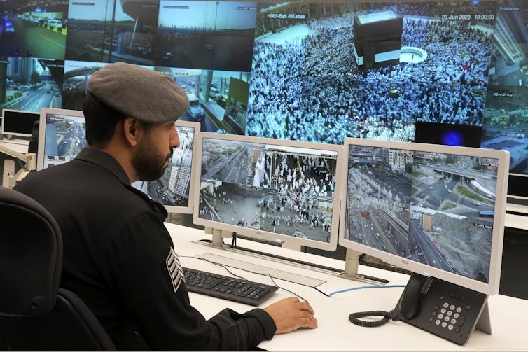 Picture of a security officer looking at CCTV monitors in Mecca during Hajj