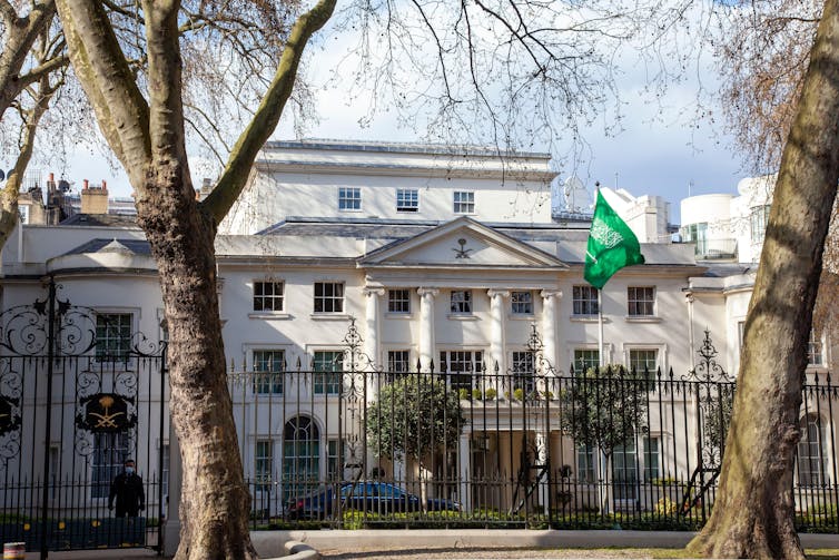 A building behind gates and trees.
