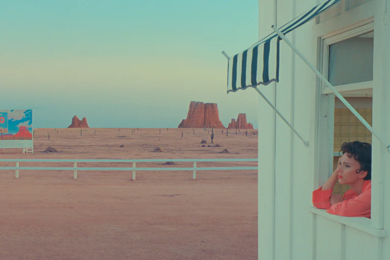 A woman looks out her window at a barren landscape