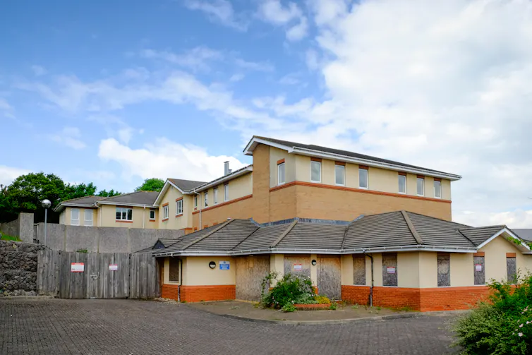 A modern day building of orange and red brick with cream rendering.