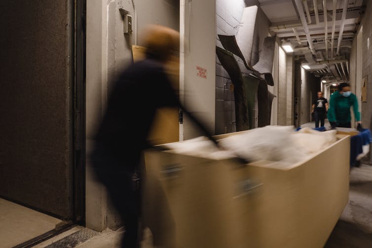 People seen pulling a bin through a hallway.