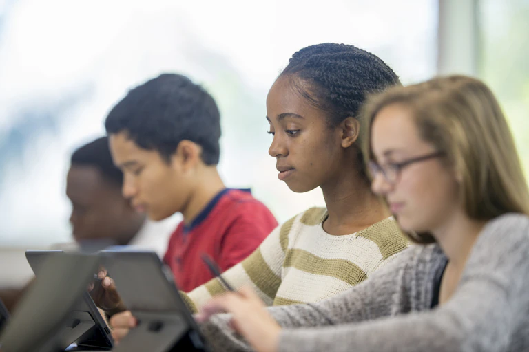 A group of students scrolling and reading on their tablets