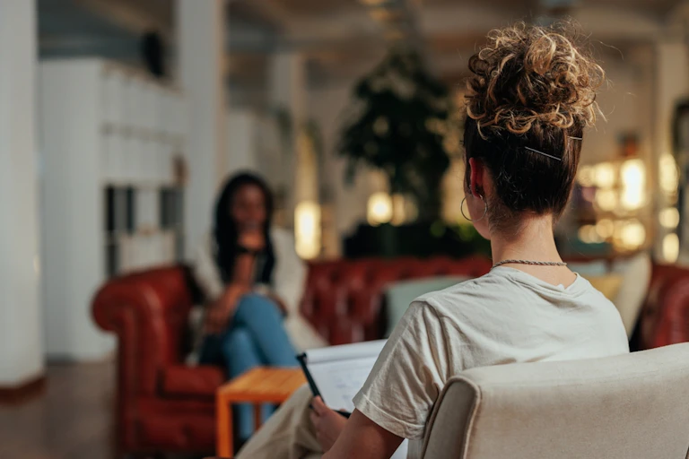 Female patient sitting on sofa in talk therapy