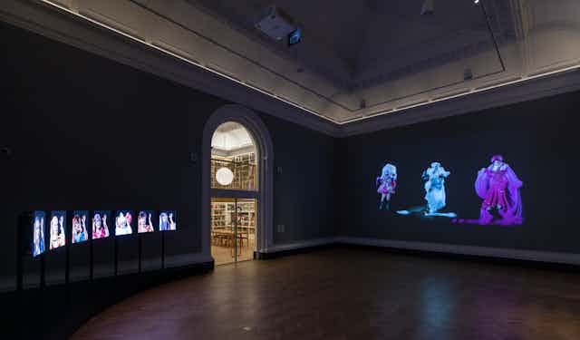 A darkened gallery showing a colourful photography exhibition.