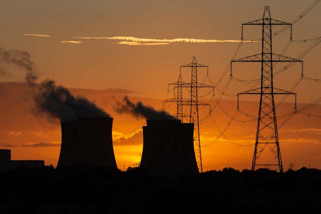 Cooling towers and pylons at sunset