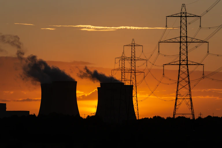 Cooling towers and pylons at sunset