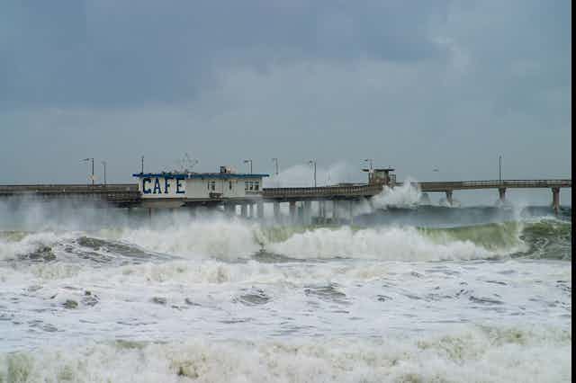 Stormy waves crashing into a pier.