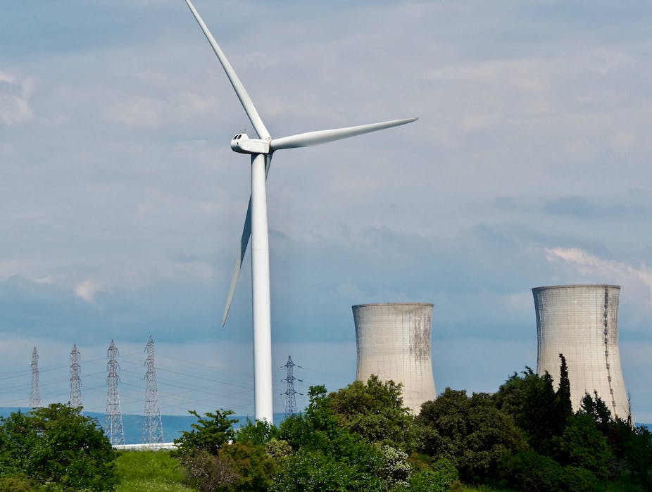 paysage avec une éolienne à l'avant et une centrale nucléaire à l'arrière